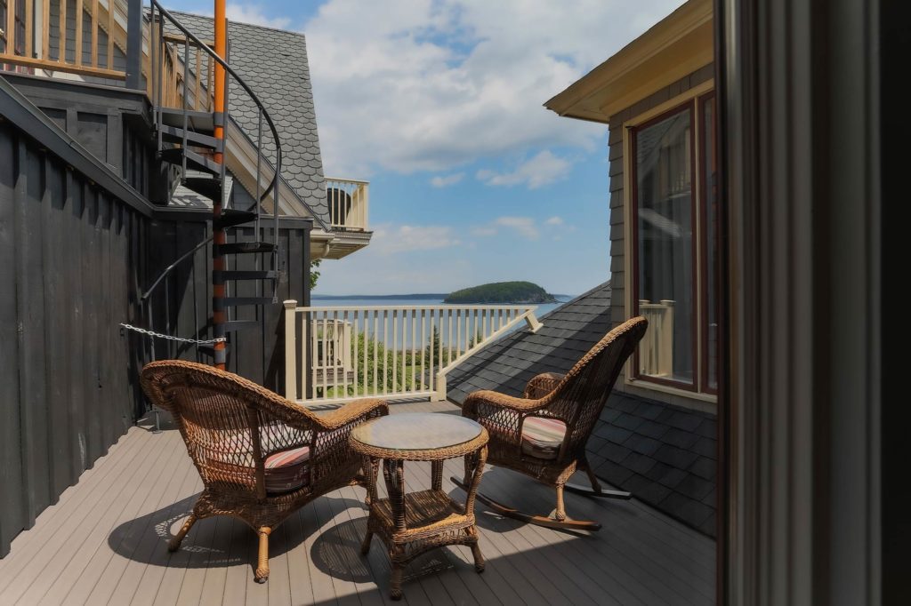 Veranda with whicker chairs overlooking ocean.