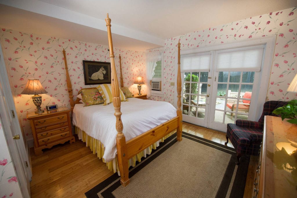Four poster bed in a bright traditionally decorated hotel room.